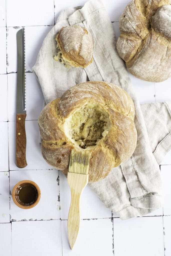 bread bowl being brushed with butter