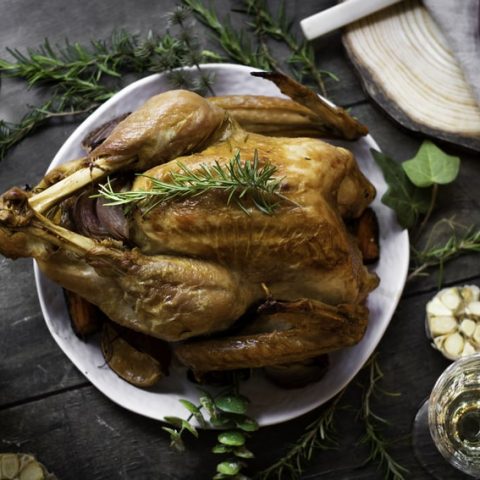 roasted turkey on a plate on a black counter