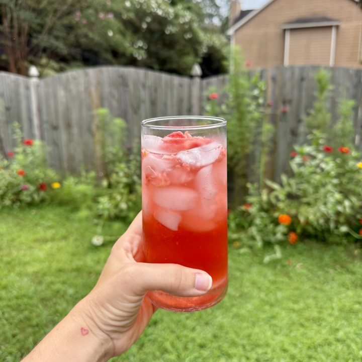 hand holding a strawberry acai refresher outside