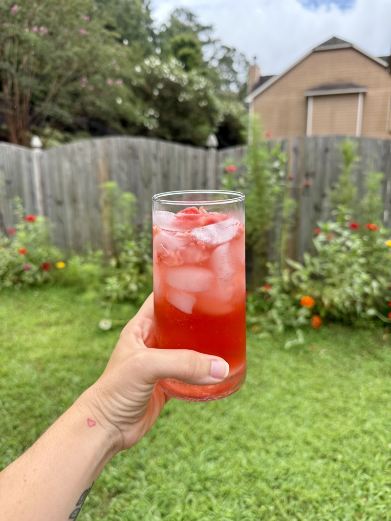hand holding a strawberry acai refresher outside