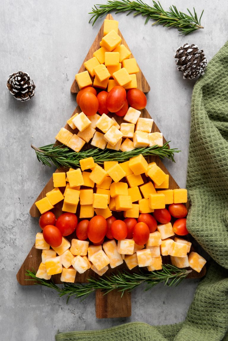 Christmas tree cheese board made with cubed cheese and tomatoes