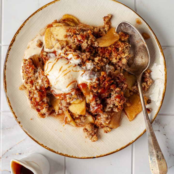 serving of apple crisp with vanilla ice cream on a plate
