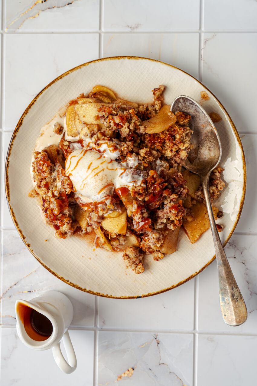 serving of apple crisp with vanilla ice cream on a plate